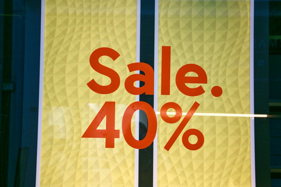 Close-up of a bright yellow garden shed door with a textured diamond pattern, displaying a prominent red sign that reads 'Sale. 40%' in bold letters. The sign appears to be a window decal or painted o